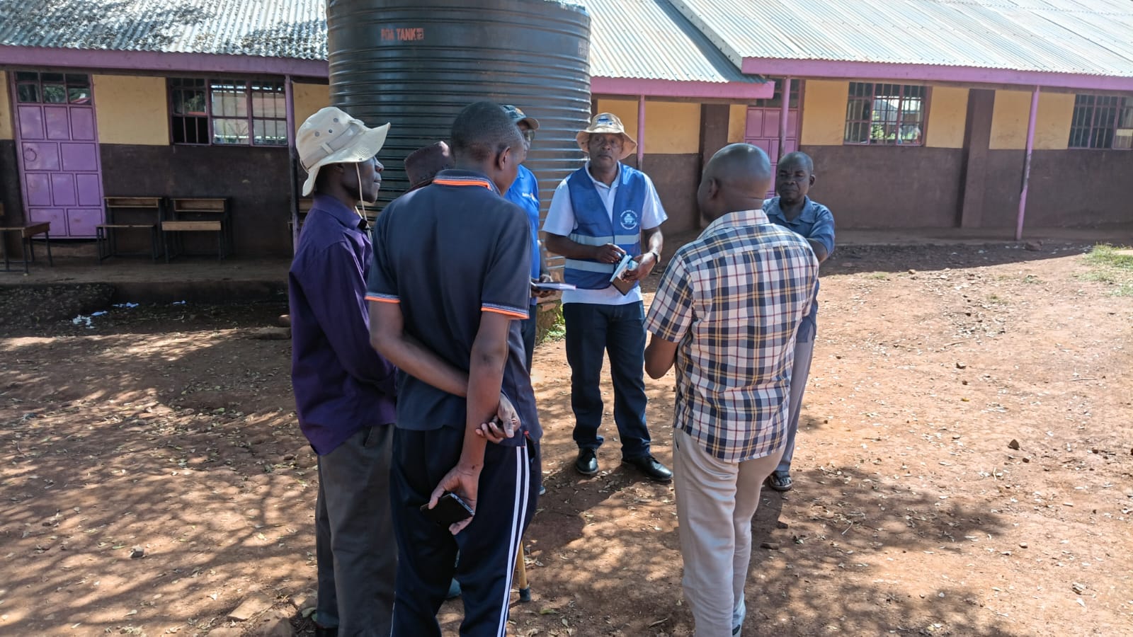 Site team reviewing a water tank installation at a school